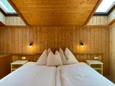 a bedroom with a bed in a wooden wall at Chalet Forciagn in San Vigilio Di Marebbe