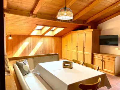 a dining room with a table and a tv at Chalet Forciagn in San Vigilio Di Marebbe