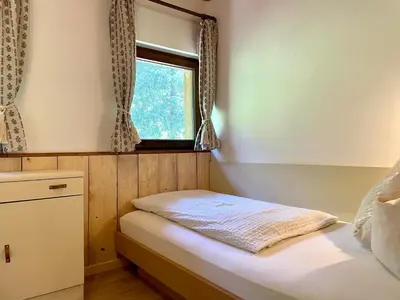 a small bedroom with a bed and a window at Chalet Forciagn in San Vigilio Di Marebbe