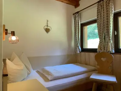a small bedroom with a bed and a window at Chalet Forciagn in San Vigilio Di Marebbe