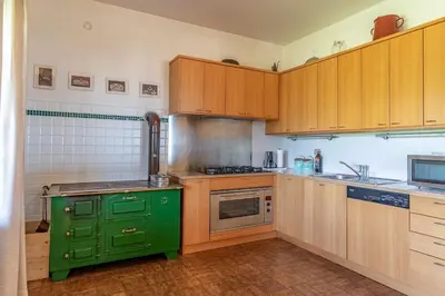 a kitchen with a green stove and wooden cabinets at Dolomites White Rest - Mountain View in Tres