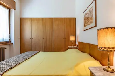 a bedroom with a yellow bed and a cabinet at Dolomites White Rest - Mountain View in Tres