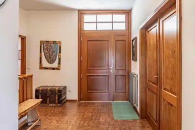 a hallway with a wooden door with a window at Dolomites White Rest - Mountain View in Tres