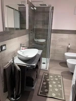 a bathroom with two sinks and a glass shower at Dolomites Holiday Home in Canazei