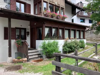 a house with flower boxes on the roof at Dolomites Holiday Home in Canazei