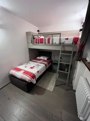 a small room with a bunk bed and a ladder at Dolomites Holiday Home in Canazei