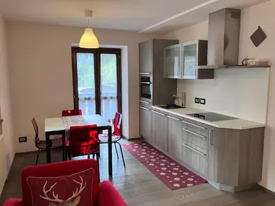 a kitchen with a table and a dining room at Dolomites Holiday Home in Canazei