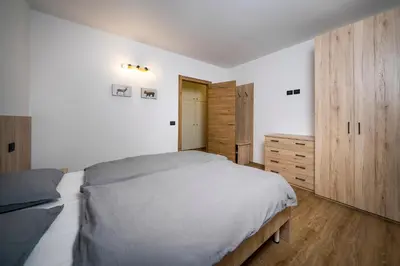 a bedroom with a large bed and wooden cabinets at Cauriol Suites 1.1 in Cavalese