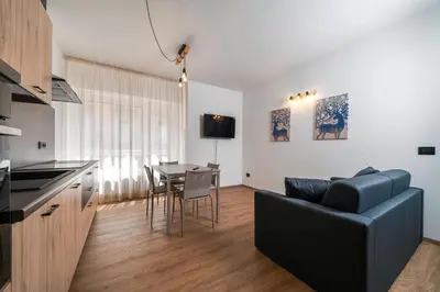 a kitchen and living room with a couch and a table at Cauriol Suites 1.1 in Cavalese