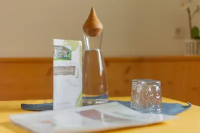 a wooden table with a spoon and a bottle on it at Pretzerhof in Campo di Trens