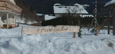 a sign in a pile of snow next to a playground at Pretzerhof in Campo di Trens