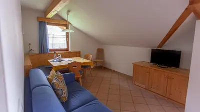 a living room with a blue couch and a television at Pretzerhof in Campo di Trens