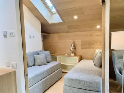 a small living room with a couch and a chair at Eurochalet in Campitello di Fassa