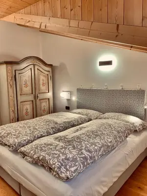 a bedroom with a large bed with a wooden headboard at Eurochalet in Campitello di Fassa