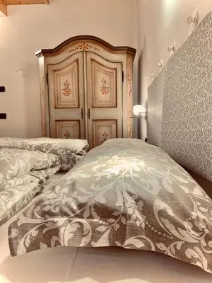 a bedroom with a bed with a headboard and a bed sidx sidx at Eurochalet in Campitello di Fassa