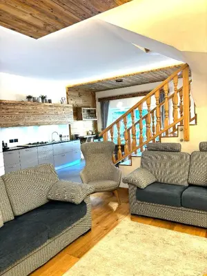 a living room with two couches and a kitchen at Eurochalet in Campitello di Fassa