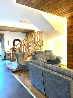 a living room with a couch and a staircase at Eurochalet in Campitello di Fassa