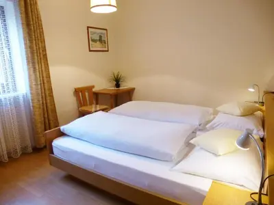 a bedroom with two beds with white sheets at Apartment Weissenegger in Fiè