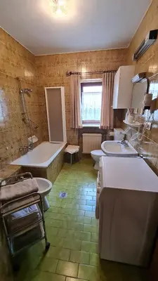 a bathroom with two sinks and a tub and two toilets at Apartment Weissenegger in Fiè
