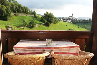 a table and two chairs on a balcony with a view at Apartment Weissenegger in Fiè