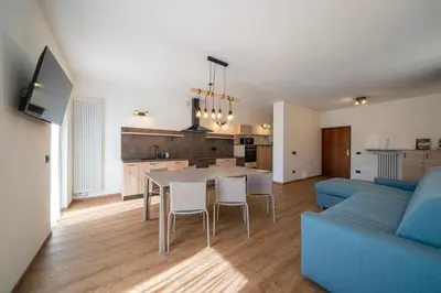 a living room with a table and a blue couch at Cauriol Suites 2.3 in Cavalese
