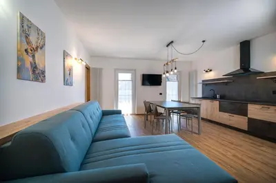 a living room with a blue couch and a table at Cauriol Suites 2.3 in Cavalese