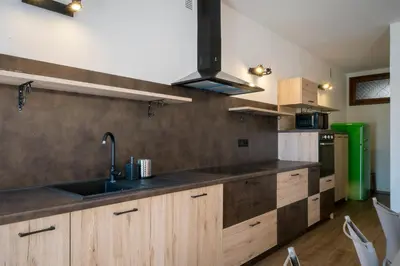 a kitchen with wooden cabinets and a sink at Cauriol Suites 2.3 in Cavalese