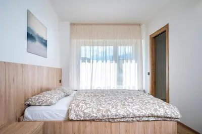 a bedroom with a bed with a large window at Cauriol Suites 2.3 in Cavalese