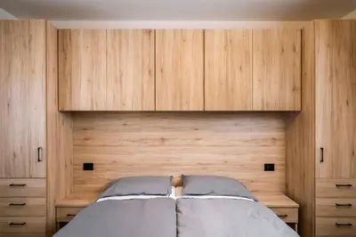 a bedroom with a bed with wooden cabinets at Cauriol Suites 2.3 in Cavalese