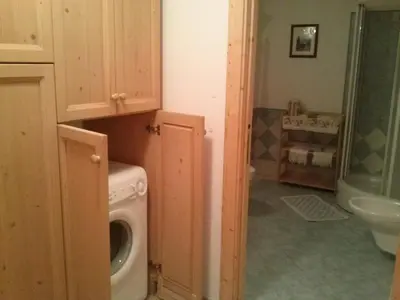 a laundry room with a washing machine in a bathroom at Apartments Cableway Canazei in Canazei