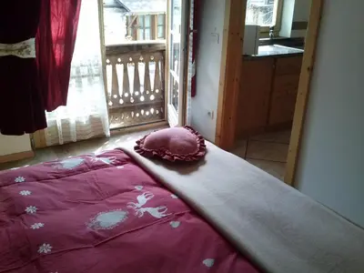a bed with a pink comforter in a room at Apartments Cableway Canazei in Canazei
