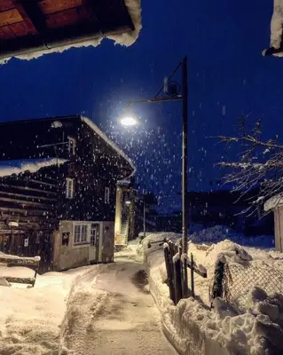 a street light in the snow at night at Apartments Cableway Canazei in Canazei