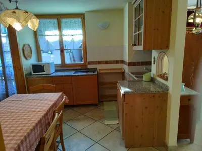 a kitchen with wooden cabinets and a counter top at Apartments Cableway Canazei in Canazei