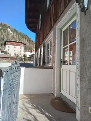 an open door of a building with a fence at Apartments Cableway Canazei in Canazei