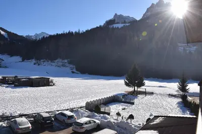 a group of cars parked in a snow covered field at Park Hotel Mater Dei in Pozza di Fassa