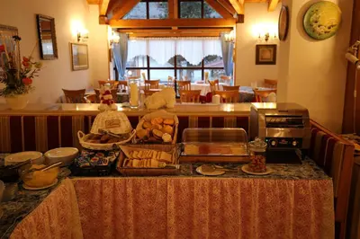 a kitchen with a table with food on it at Park Hotel Mater Dei in Pozza di Fassa