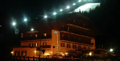 a building with lights on top of it at night at Park Hotel Mater Dei in Pozza di Fassa