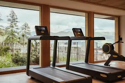 two treadmill machines in a gym with windows at Kolfuschgerhof Mountain Resort in Colfosco