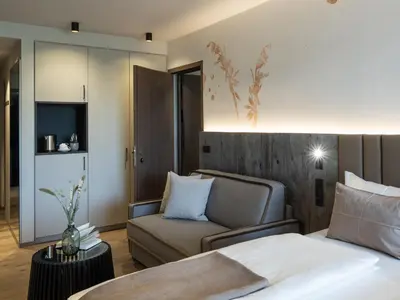 a bedroom with a bed and a chair and a couch at Arieshof in Floronzo