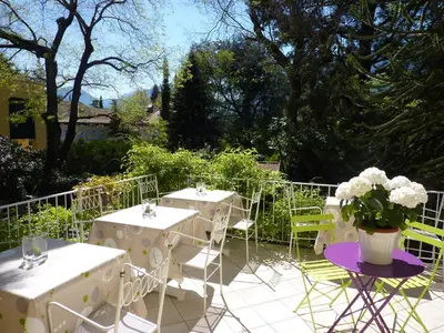 two tables and chairs with flowers on a patio at Hotel Zima in Merano