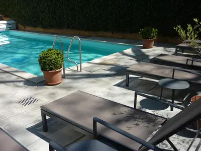 a group of tables and chairs next to a swimming pool at Hotel Zima in Merano