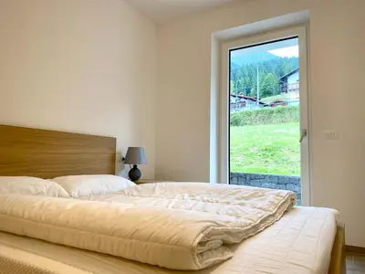 a bedroom with a large bed and a window at Casa Scardanzan in Canale dʼAgordo