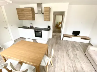 a kitchen and living room with a wooden table and chairs at Casa Scardanzan in Canale dʼAgordo