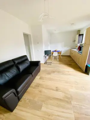 a living room with a black couch and a table at Casa Scardanzan in Canale dʼAgordo
