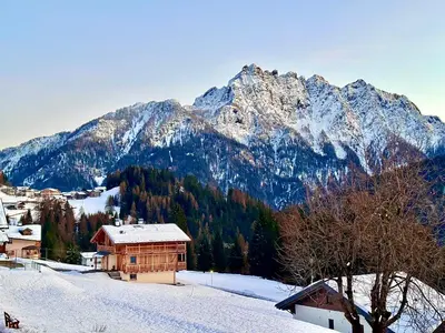 a snow covered mountain with a house in the foreground at Casa Scardanzan in Canale dʼAgordo