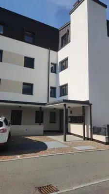 a white building with a car parked in front of it at Apartment Oleander - Alpstay in Naturno