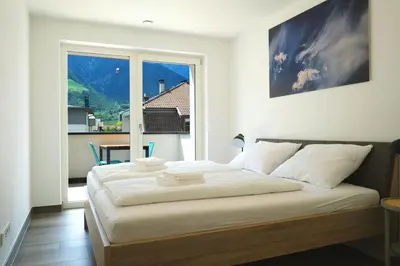 a bedroom with a large bed with a large window at Apartment Oleander - Alpstay in Naturno
