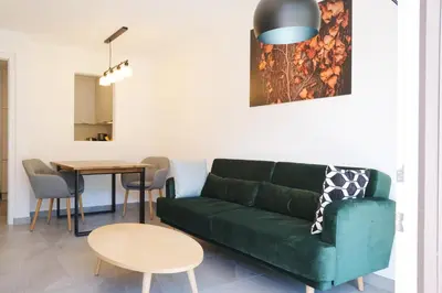 a living room with a green couch and a table at Apartment Oleander - Alpstay in Naturno