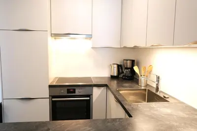 a kitchen with white cabinets and a sink at Apartment Oleander - Alpstay in Naturno