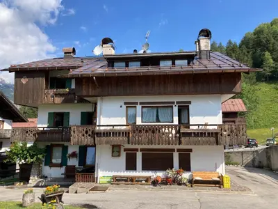 a house with a balcony on top of it at Appartamento Cortina d'Ampezzo Lovely Hearts in Cortina dʼAmpezzo